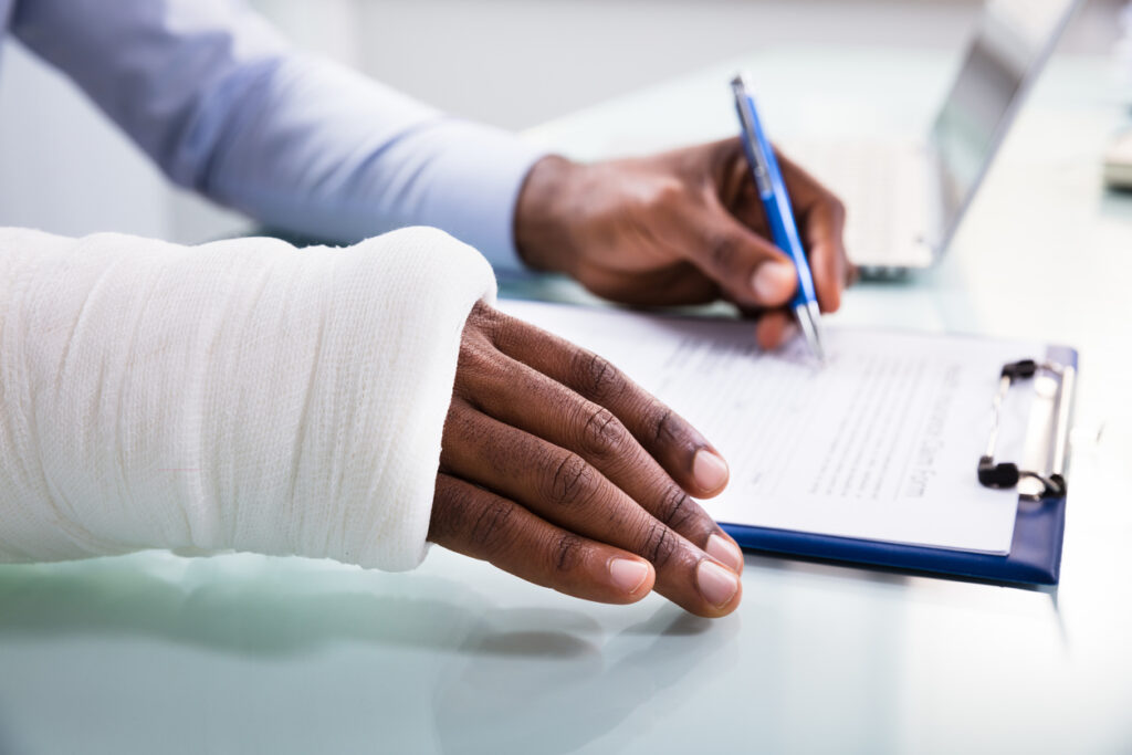 Injured Man Filling Insurance Claim Form