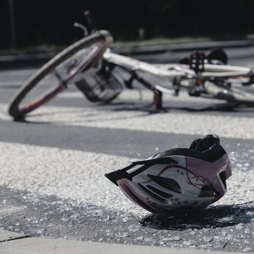 Broken child's helmet and bike on pedestrian crossing after terrible accident