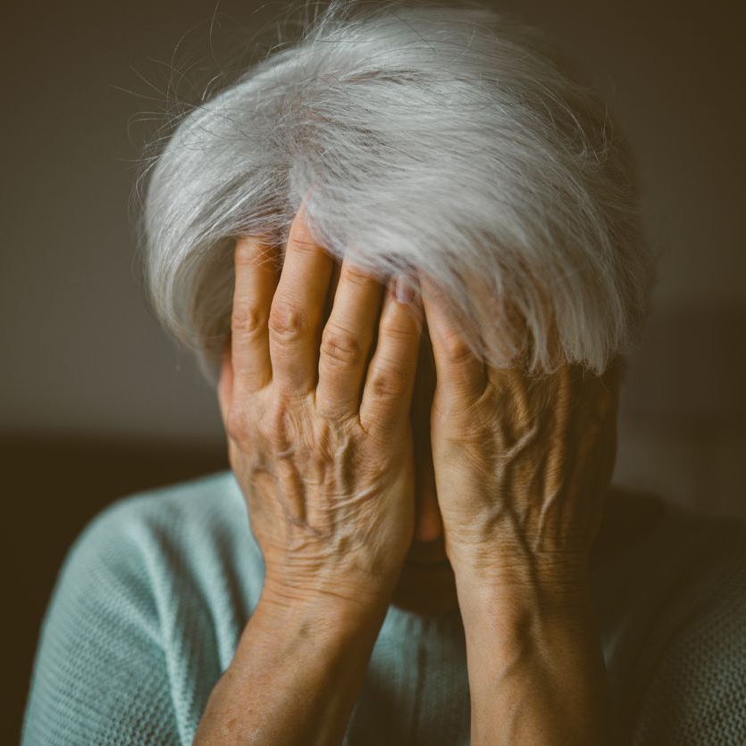 Senior woman covering face with her hands