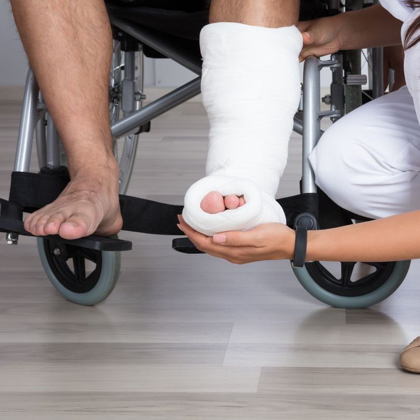 Close-up Of A Female Doctor Holding Disabled Patient's Leg In Clinic