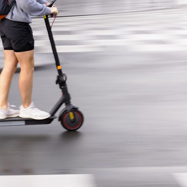 motion blur picture of an unrecognizable person with an electric scooter on a city street. High speed